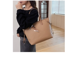 Detail view of khaki leather tote bag with elegant silk scarf and side drawstring