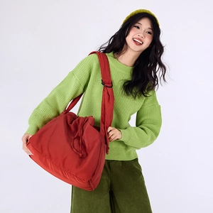 Detail of red drawstring shoulder bag showing durable fabric texture and spacious design