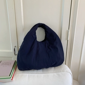 Dettaglio della borsa tote imbottita blu navy con morbida consistenza puffer