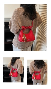 Détail du sac à bandoulière en PU mat rouge avec nœud décoratif et perle en bois