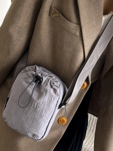 Minimalist light grey drawstring crossbody bag for women with adjustable shoulder strap