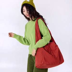 Detailed side view of a large red drawstring tote bag on model for daily commuting