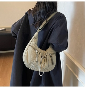 Close-up of olive green nylon crossbody bag showing the woven zipper and textured fabric