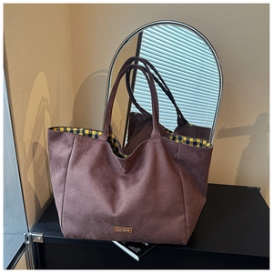 Detail of suede tote bag showing its premium plaid lining and small leather logo label