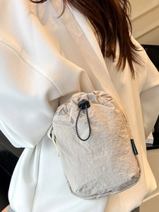 Beige nylon drawstring crossbody phone bag with wide strap and fashion woven label