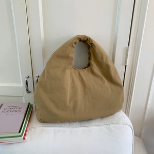 Dettaglio borsa tote kaki minimalista con tessuto dalla trama stropicciata e manico unito