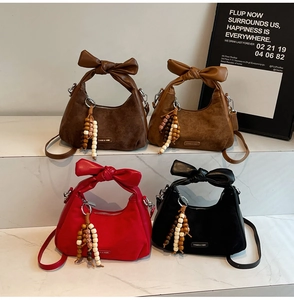 Détail de quatre sacs en daim marron rouge et noir avec des poignées en nœud