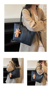 Detail of black large capacity tote bag with vintage texture and cute plush bear charm