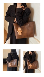 Detail of vintage brown tote bag with textured faux leather and plush bear charm decoration