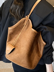 Brown suede bucket bag with leather trim and decorative pendant for women commuting