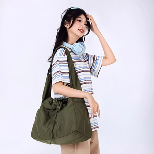 Detail view of olive green drawstring shoulder bag showing waterproof nylon texture and strap