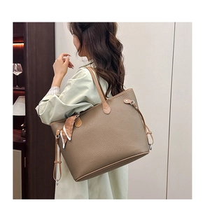 Detail of khaki leather tote bag with lychee texture and fashion printed silk scarf