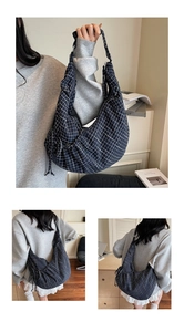 Detail of navy blue plaid canvas tote bag showing drawstring texture and side view strap