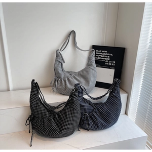 Detail of checkered crescent bags in gray, black, and navy with drawstring pleats