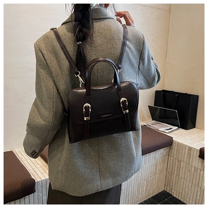 Detail view of the vintage dark brown faux leather bag worn as a stylish backpack