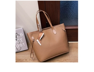 Detailed macro view of caramel lychee leather tote bag with silk scarf on handle