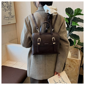 Detail view of deep brown vintage PU leather backpack with gold metal buckles and straps