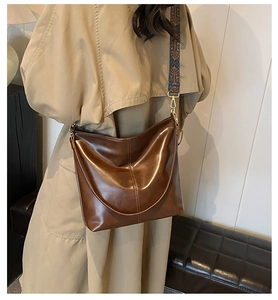 Détail du sac seau en cuir ciré vintage avec bandoulière large à fleurs bleues rétro
