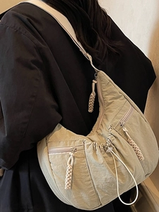 Stylish light khaki crescent crossbody bag with multiple zip pockets and woven pullers