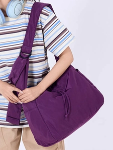 Large purple drawstring nylon shoulder bag with wide strap for casual commuting