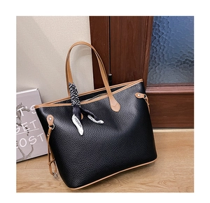 Detailed view of black lychee grain tote bag with silk scarf handle and contrast edges