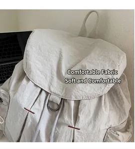 Dettaglio della morbida trama in nylon beige e delle cuciture rinforzate dello zaino