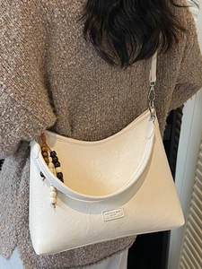 White vintage crescent hobo bag with bohemian bead handle and minimalist texture