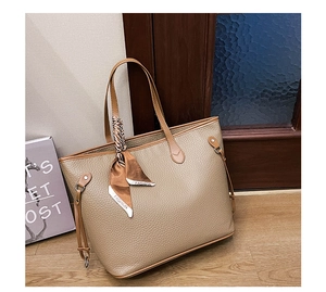 Detailed macro view of khaki lychee grain leather tote bag with stylish fashion silk scarf