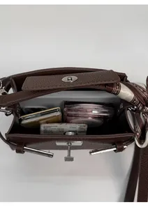 Deep brown lychee leather handbag showing internal capacity for phone and essentials
