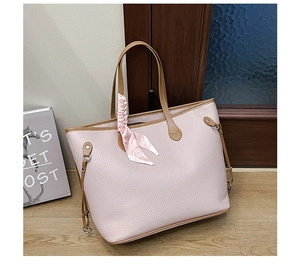 Detail of light pink pebble leather tote bag featuring a decorative silk scarf on handle