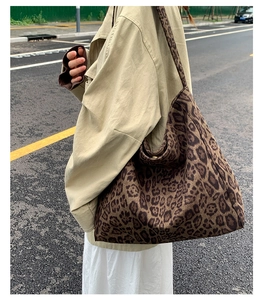 Vista urbana di una borsa hobo leopardata di grandi dimensioni indossata da una modella