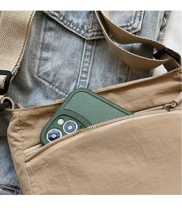 Detail of khaki nylon crossbody bag showing outer zipper pocket for secure phone storage
