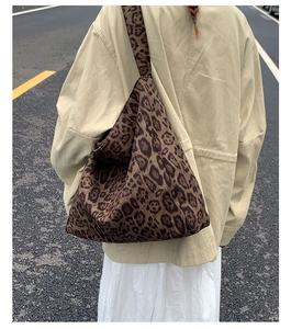 Scatto street style di una donna con una borsa tote leopardata su una giacca beige