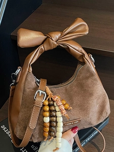 Sac à bandoulière carré minimaliste en daim marron avec poignée en nœud et pompon