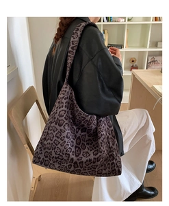 Dettaglio della borsa tote grande con stampa leopardata viola e outfit in pelle nera