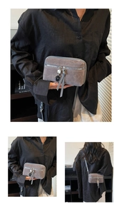 Detail view of grey frosted crossbody bag featuring silver zipper and bear charm