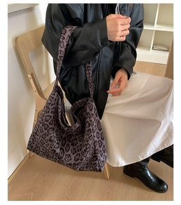 Foto lifestyle della borsa tote grande con stampa leopardata viola e nera e tracolla