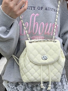 White quilted mini backpack with chain straps and pearl drawstring detail on model