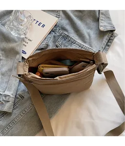 Internal view of khaki canvas crossbody bag showing spacious compartments with phone and wallet
