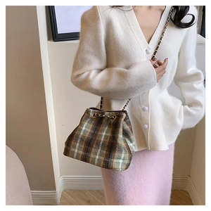 Detail of vintage green plaid wool bucket bag with gold chain drawstring closure