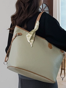 Elegant olive green tote bag with litchi texture and silk scarf shown on model