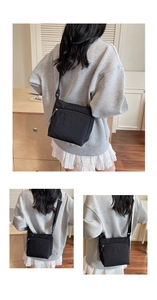 Detailed view of black nylon crossbody bag with waterproof texture and front zipper pocket