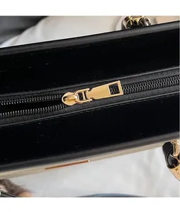 Detail shot of smooth gold-tone zipper hardware on the premium black tote bag