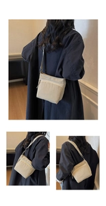 Detail view of the adjustable wide nylon strap and zipper closure on the khaki canvas bag