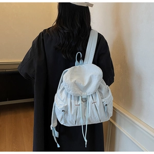 Detalle de la mochila de nylon verde menta con cordón ajustable y bolsillos laterales