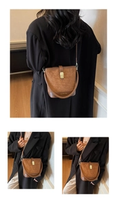 Detail view of retro brown bucket bag with gold lock and adjustable leather straps
