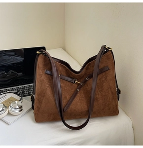 Close-up of brown vintage large capacity tote bag with suede texture and metal buckles