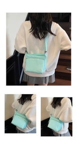 Detail view of mint blue nylon crossbody bag with zipper pockets and adjustable strap