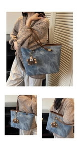 Detail of blue tote bag with marble texture, brown leather handle and cute plush charm