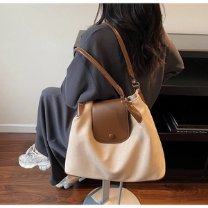 Detail of the large capacity color-block tote bag on a model in a lifestyle setting
